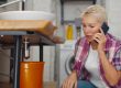 Sad,Mature,Woman,Calling,Plumber,Having,Water,Leaking,From,Sink