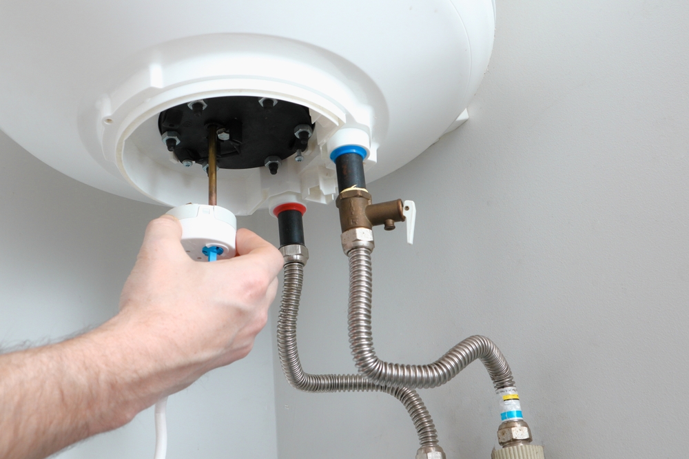 The,Hand,Of,A,Plumber,Installs,A,Thermostat,In,A The,Hand,Of,A,Plumber,Installs,A,Thermostat,In,A
