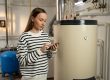 A,Young,Woman,Examines,A,Non-operational,Boiler,With,Concern,,Holding